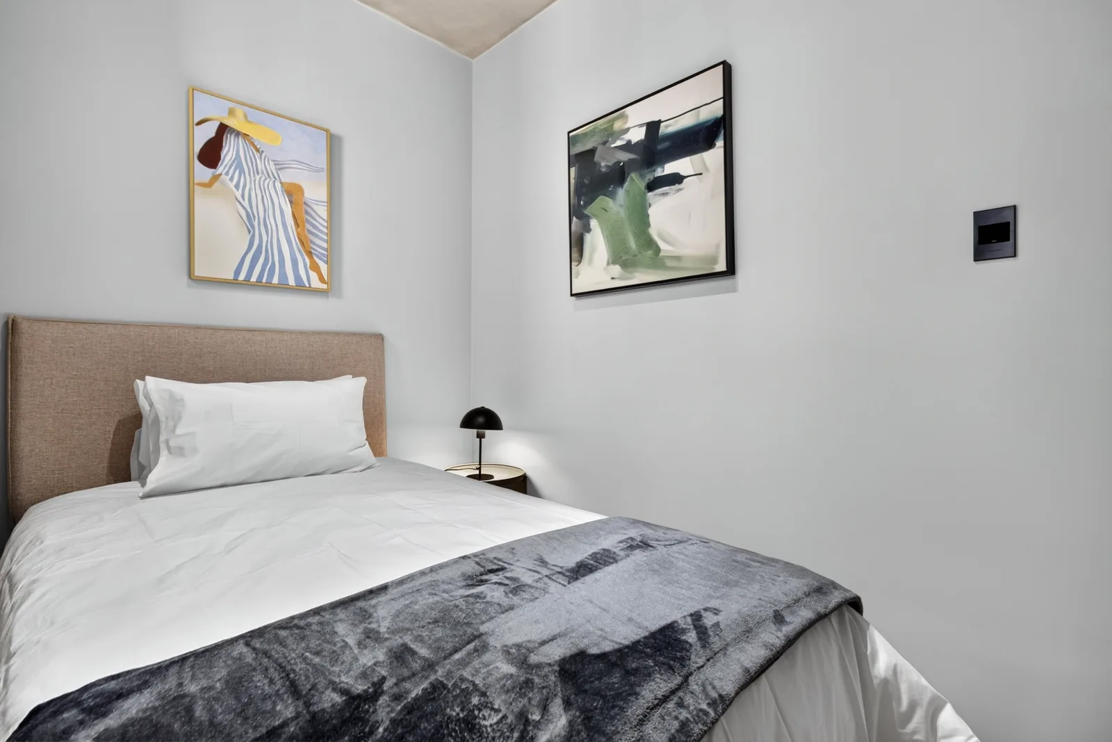 Second bedroom corner with two framed works